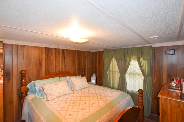 bedroom featuring wood walls and a textured ceiling