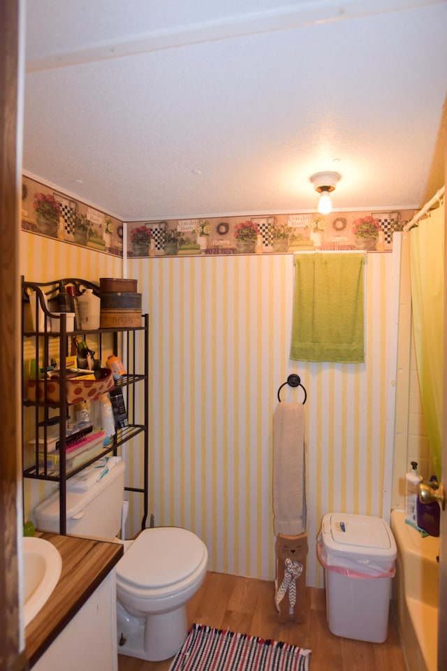 full bathroom featuring hardwood / wood-style floors, vanity, toilet, and shower / tub combo with curtain