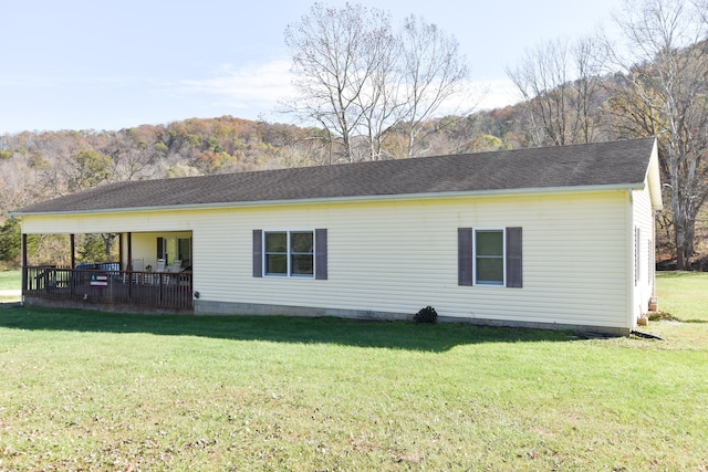 rear view of property with a lawn and a wooden deck