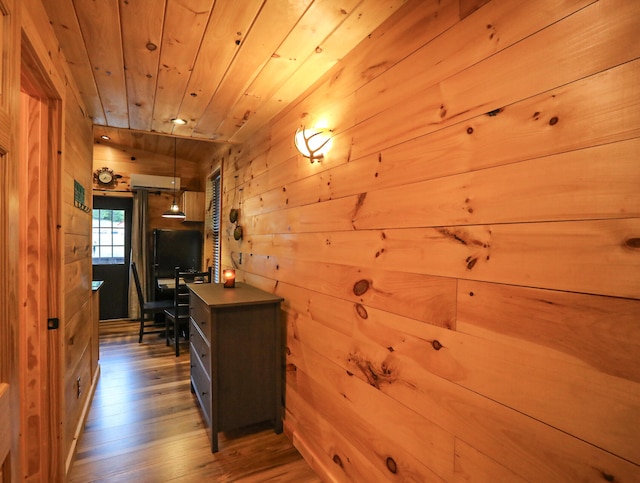 hall featuring hardwood / wood-style flooring, wooden walls, and wood ceiling