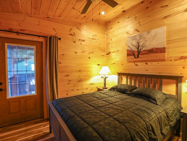 bedroom featuring wood ceiling, wooden walls, vaulted ceiling, and hardwood / wood-style flooring