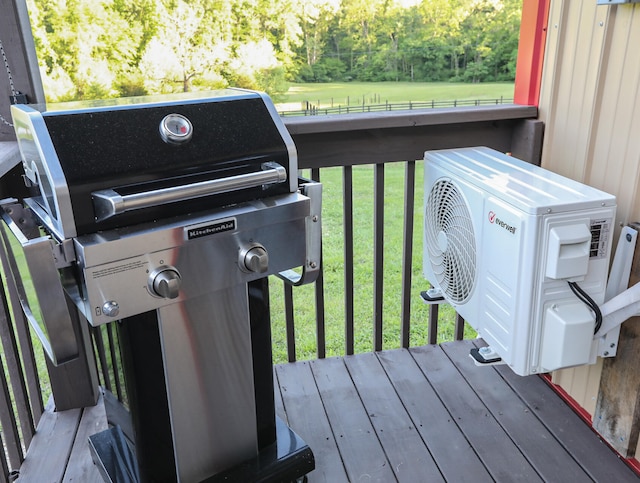 wooden deck with ac unit, a yard, and a grill