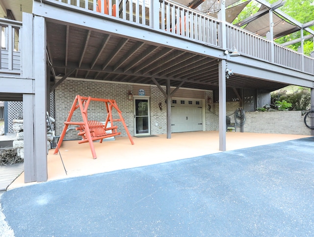 view of patio featuring a wooden deck and a garage