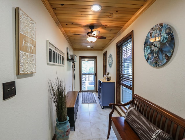 doorway with wood ceiling, ceiling fan, light tile patterned floors, and crown molding