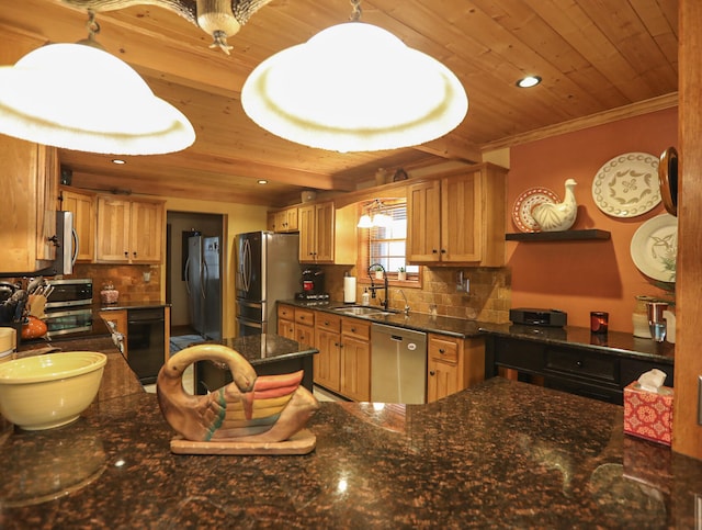 kitchen featuring pendant lighting, backsplash, appliances with stainless steel finishes, and sink