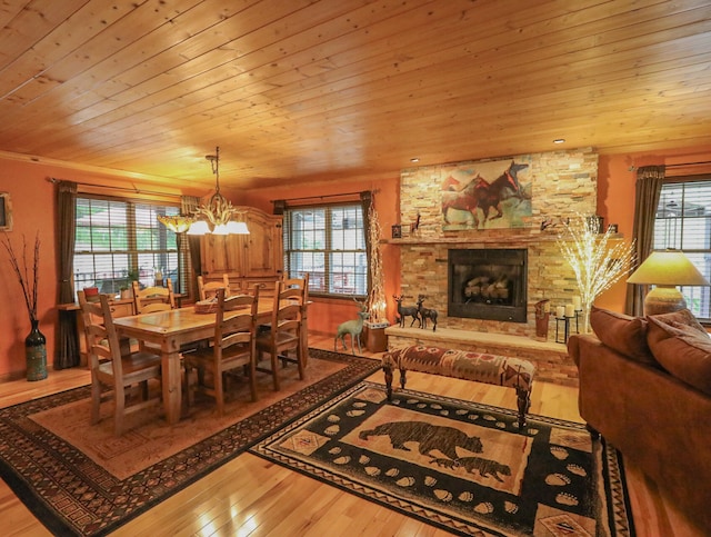 dining area with plenty of natural light, hardwood / wood-style floors, and a stone fireplace