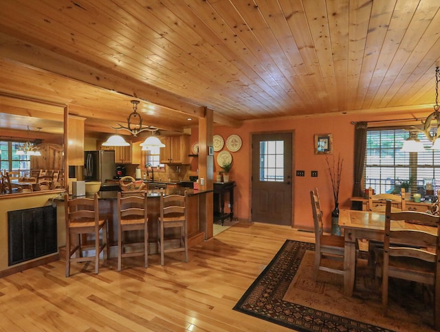 dining room featuring an inviting chandelier, light hardwood / wood-style floors, and wooden ceiling