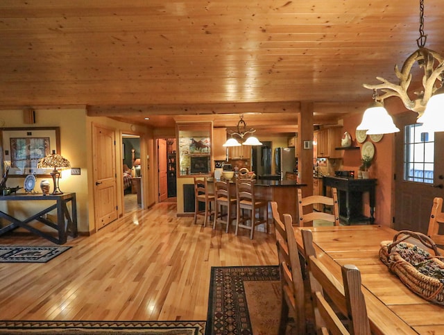 dining room featuring a chandelier, light hardwood / wood-style floors, and wooden ceiling