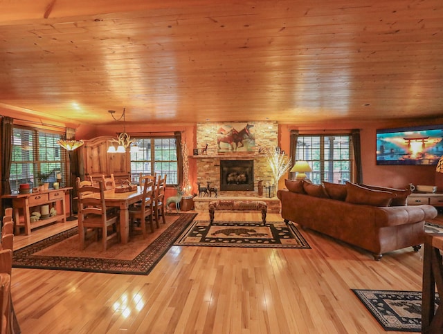 living room with light hardwood / wood-style flooring, wooden ceiling, and a wealth of natural light