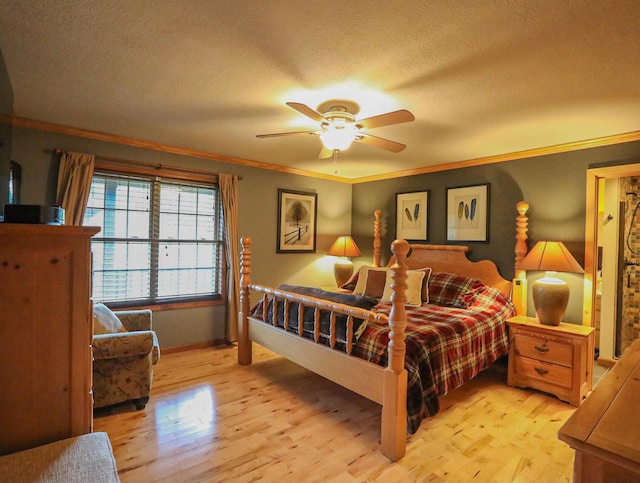 bedroom with a textured ceiling, light hardwood / wood-style floors, ornamental molding, and ceiling fan