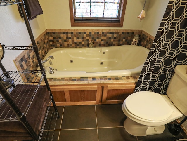 bathroom featuring tiled bath, tile patterned floors, and toilet