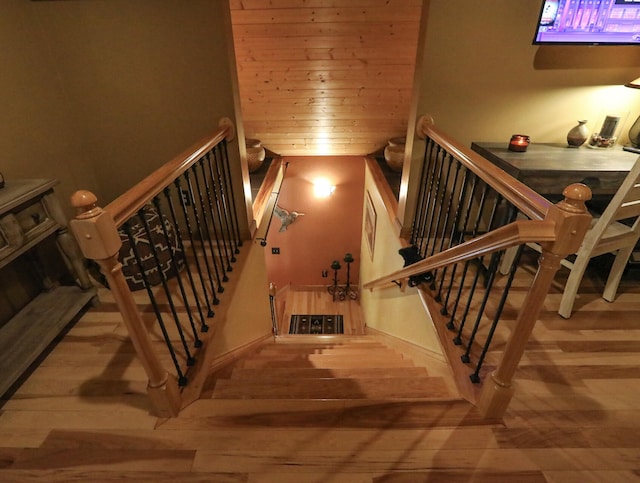 stairway featuring wood-type flooring and wooden ceiling