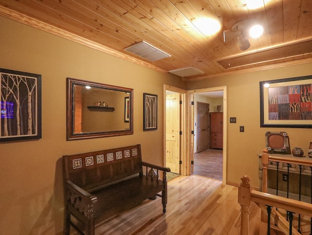 hall with hardwood / wood-style flooring, wood ceiling, and ornamental molding