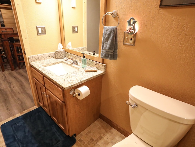 bathroom featuring hardwood / wood-style floors, vanity, and toilet