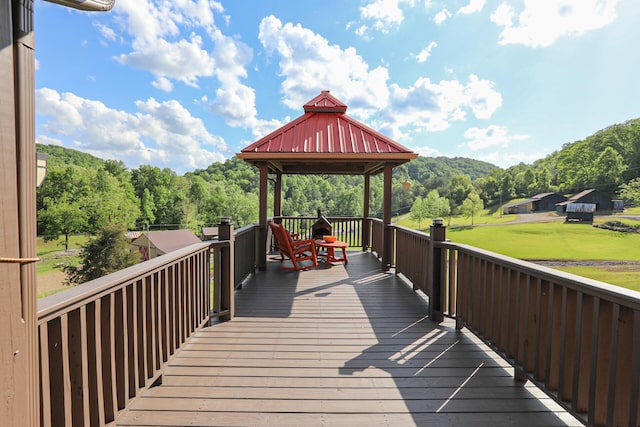 wooden terrace featuring a lawn and a gazebo