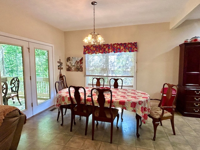 dining space featuring tile flooring, plenty of natural light, and an inviting chandelier