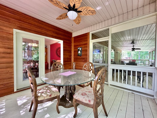 dining room featuring wood walls, ceiling fan, hardwood / wood-style floors, and wood ceiling