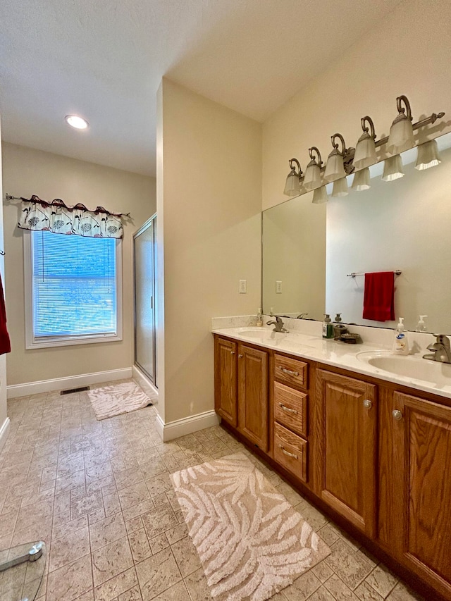 bathroom featuring dual vanity, an enclosed shower, and tile flooring