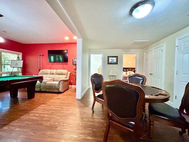 dining space featuring hardwood / wood-style floors, pool table, and a textured ceiling