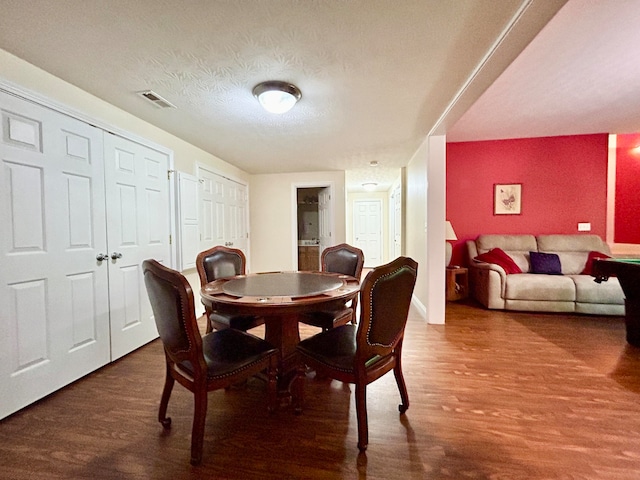 dining space with a textured ceiling and wood-type flooring