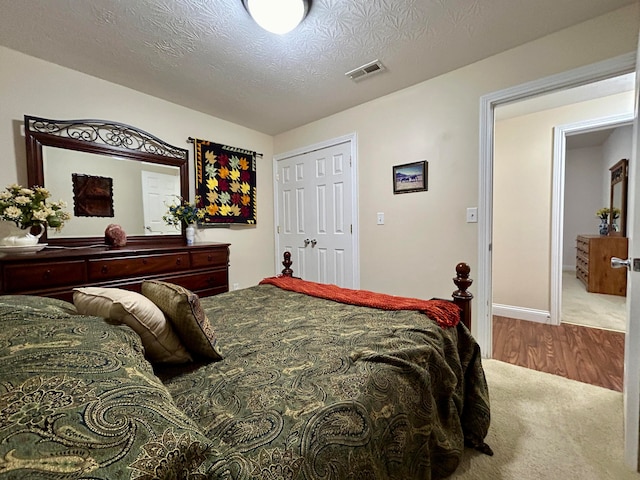 bedroom featuring a textured ceiling, a closet, and hardwood / wood-style floors