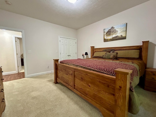 carpeted bedroom featuring a closet and a textured ceiling