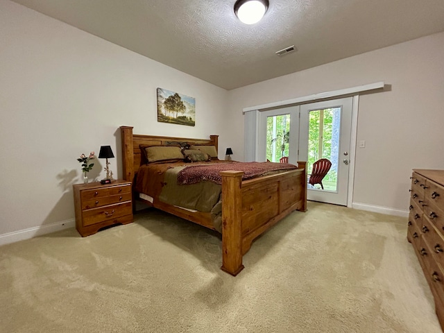 carpeted bedroom with french doors, a textured ceiling, and access to outside