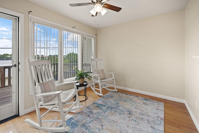 sitting room featuring ceiling fan, light wood-type flooring, and plenty of natural light