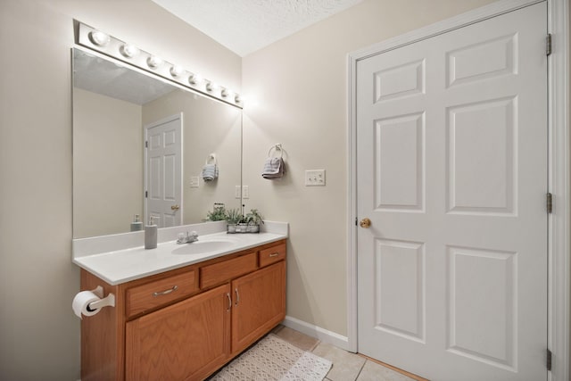 bathroom featuring a textured ceiling, tile patterned floors, and vanity