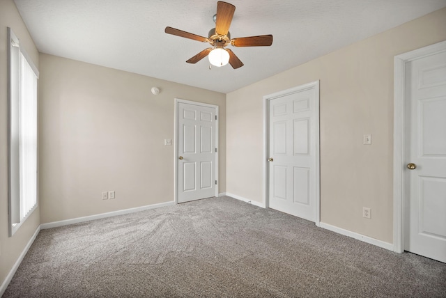 unfurnished bedroom with ceiling fan and carpet floors