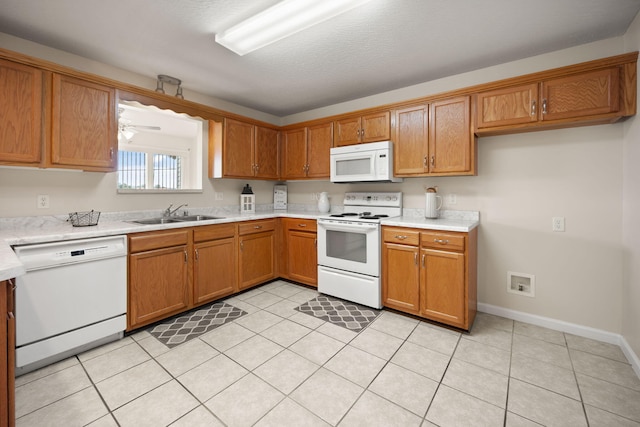 kitchen with ceiling fan, white appliances, sink, and light tile patterned floors