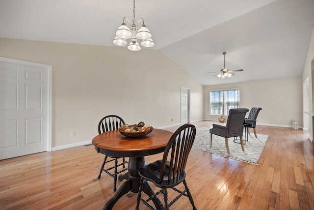 dining room featuring light wood-type flooring, ceiling fan with notable chandelier, and lofted ceiling