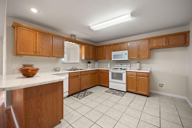 kitchen with kitchen peninsula, sink, white appliances, and light tile patterned floors