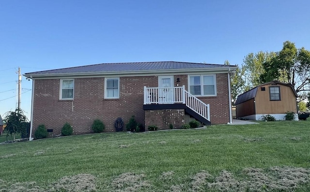 view of front of home featuring a front lawn and a storage shed