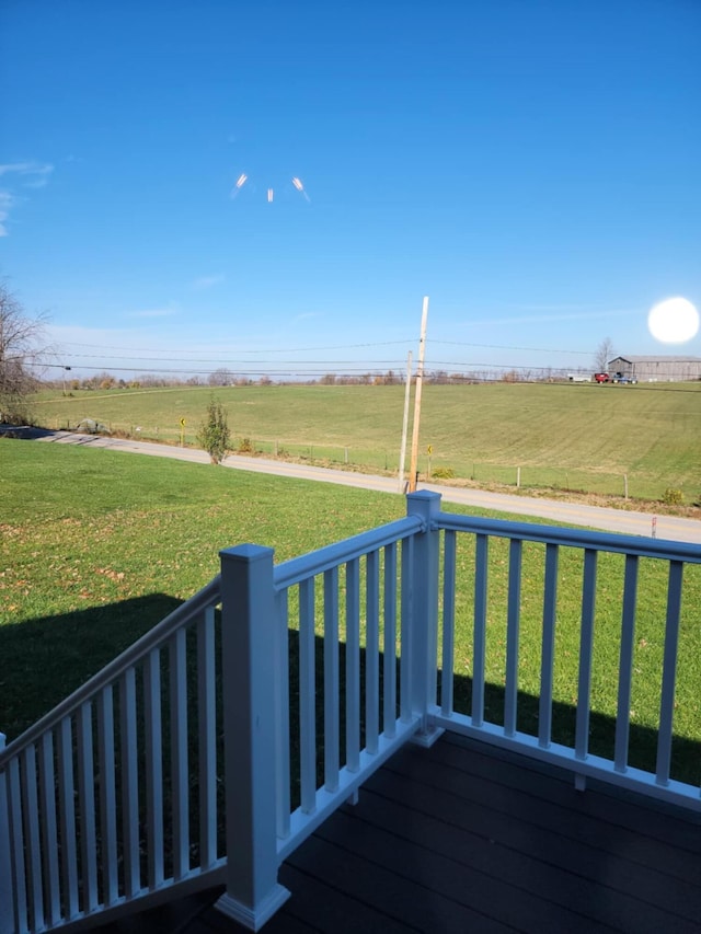 wooden deck featuring a lawn and a rural view