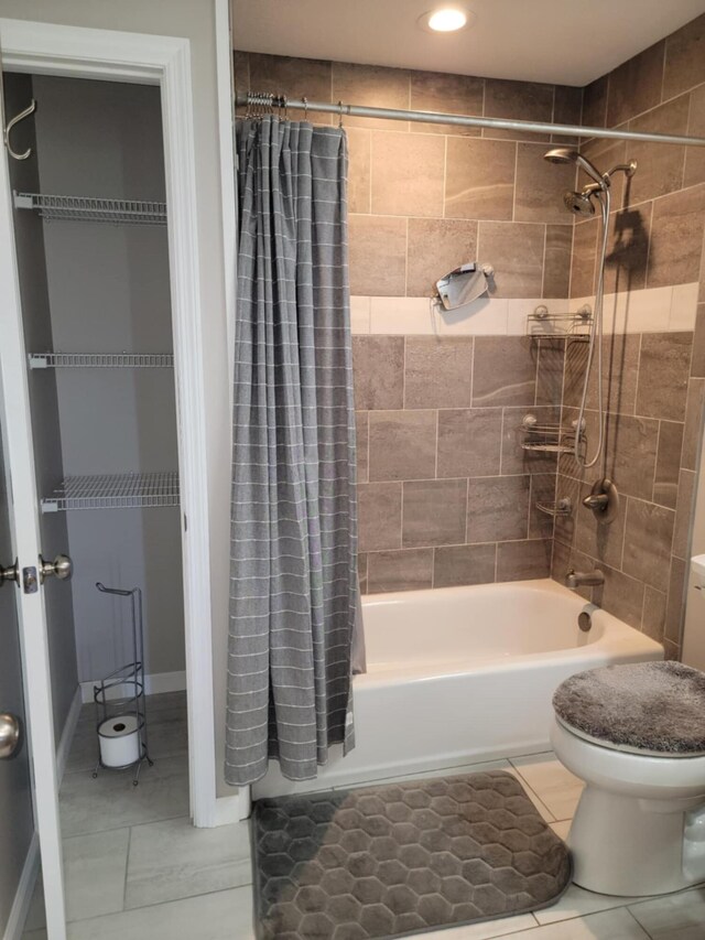 bathroom featuring tile patterned floors, shower / bathtub combination with curtain, and toilet