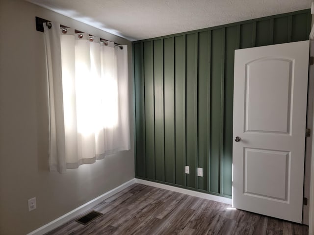 spare room with hardwood / wood-style flooring and a textured ceiling