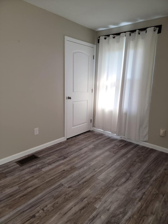 unfurnished room featuring dark wood-type flooring