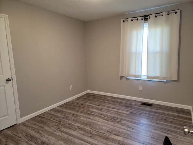 unfurnished room with a textured ceiling and hardwood / wood-style flooring