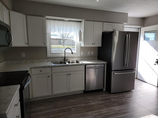 kitchen featuring dark hardwood / wood-style flooring, stainless steel appliances, white cabinetry, and sink