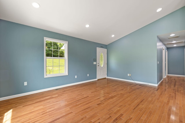 empty room featuring light hardwood / wood-style floors and vaulted ceiling