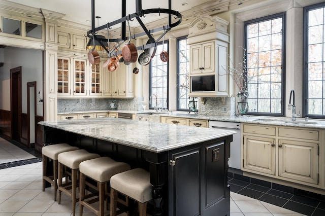 kitchen featuring a center island, backsplash, stainless steel dishwasher, and sink