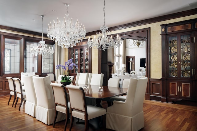 dining room with dark hardwood / wood-style flooring, crown molding, a wealth of natural light, and a notable chandelier