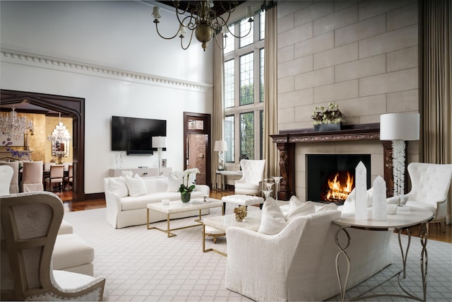 living room featuring hardwood / wood-style floors, a notable chandelier, a healthy amount of sunlight, and a high ceiling