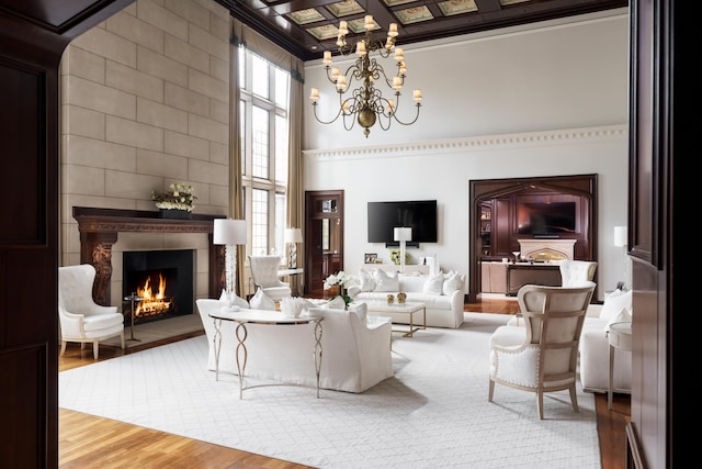 living room with a fireplace, hardwood / wood-style floors, a wealth of natural light, and a notable chandelier