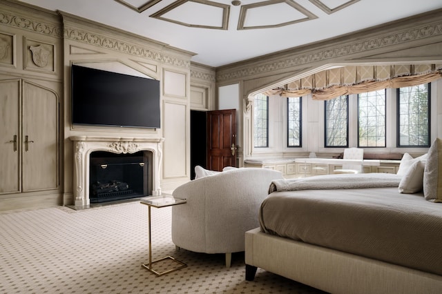 bedroom featuring a high end fireplace, carpet, and ornamental molding