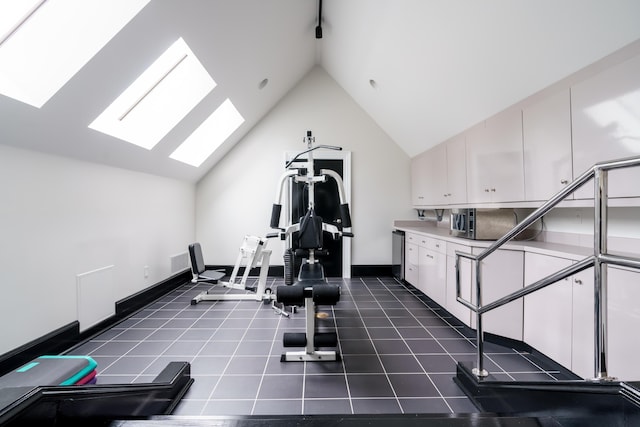 workout room featuring high vaulted ceiling and a skylight