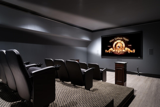 cinema with light hardwood / wood-style flooring and crown molding