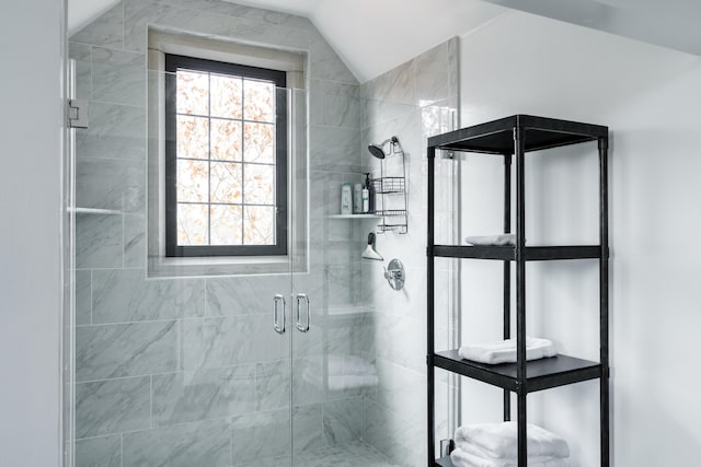 bathroom with an enclosed shower and lofted ceiling