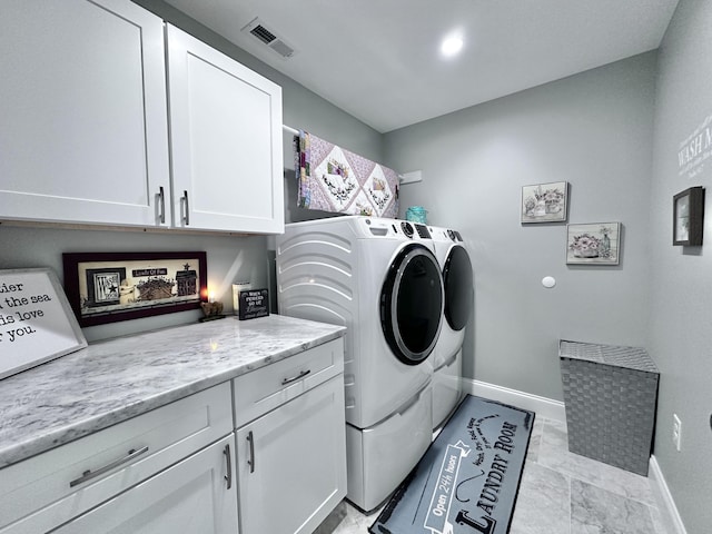 washroom featuring separate washer and dryer and cabinets